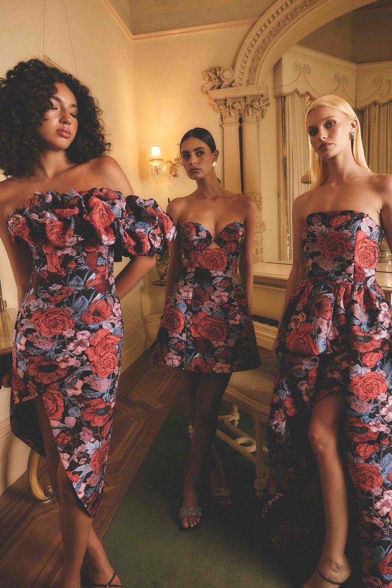 Brunette model wearing Delphine Off The Shoulder Midi Dress in Pink & Back Floral campaign shot
