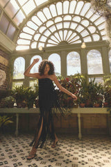 Blonde model wearing the Alya Tiered Maxi Dress in Black campaign shot