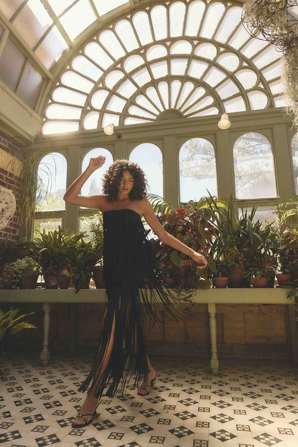 Blonde model wearing the Alya Tiered Maxi Dress in Black campaign shot