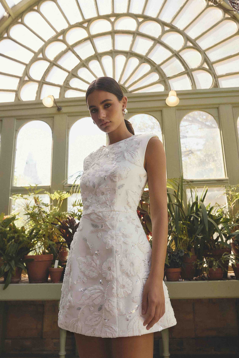 Brunette model wearing the Carol Tulip Mini Dress in White campaign shot