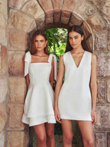 Brunette model wearing Livia Tiered Shift Mini Dress in white campaign shot