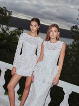 Brunette model wearing Athena Long Sleeve Lace Mini Dress in White campaign shot