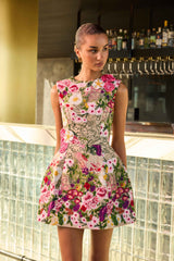 Brunette model wearing Flora Tulip Mini Dress in Pink & Green Floral campaign shot