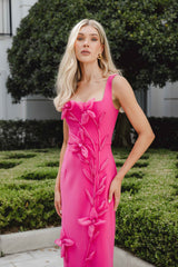 Blonde female model wears the Ilaria Midi Dress in pink in a courtyard
