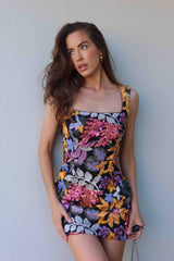 Brunette model wearing the Kiran Party Mini Dress in Orange Floral campaign shot 