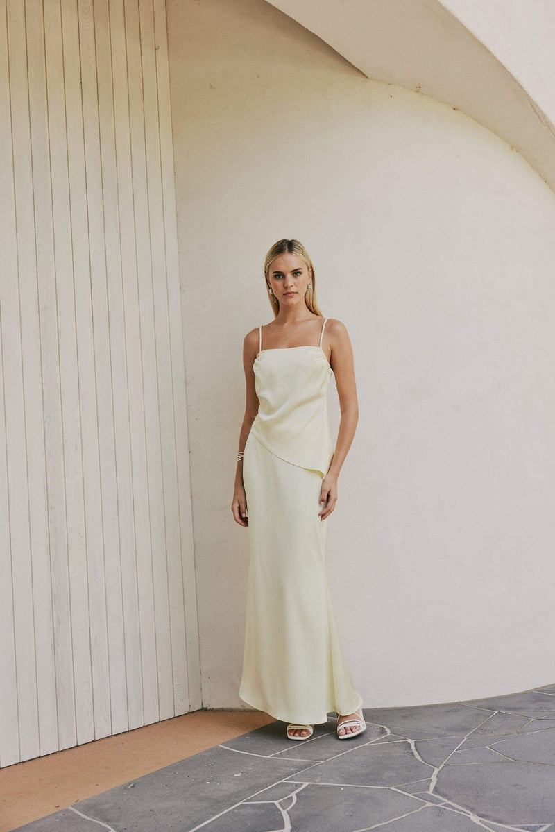 Blonde model wears CURAAE Spencer Asymmetrical Spagetti Strap Cami Top In Coco front shot