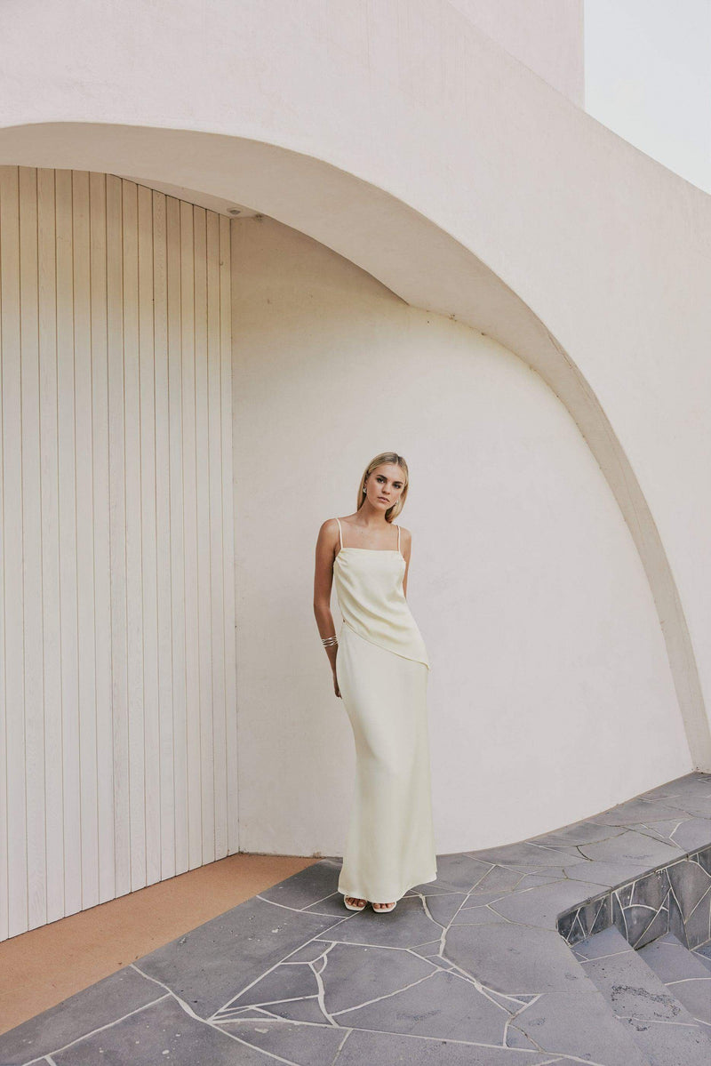 Blonde model wears CURAAE Spencer Asymmetrical Spagetti Strap Cami Top In Coco mood shot