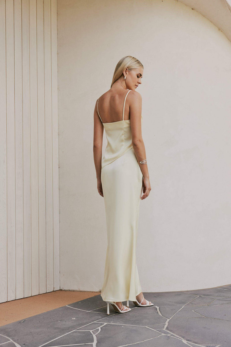 Blonde model wears CURAAE Spencer Asymmetrical Spagetti Strap Cami Top In Coco back shot