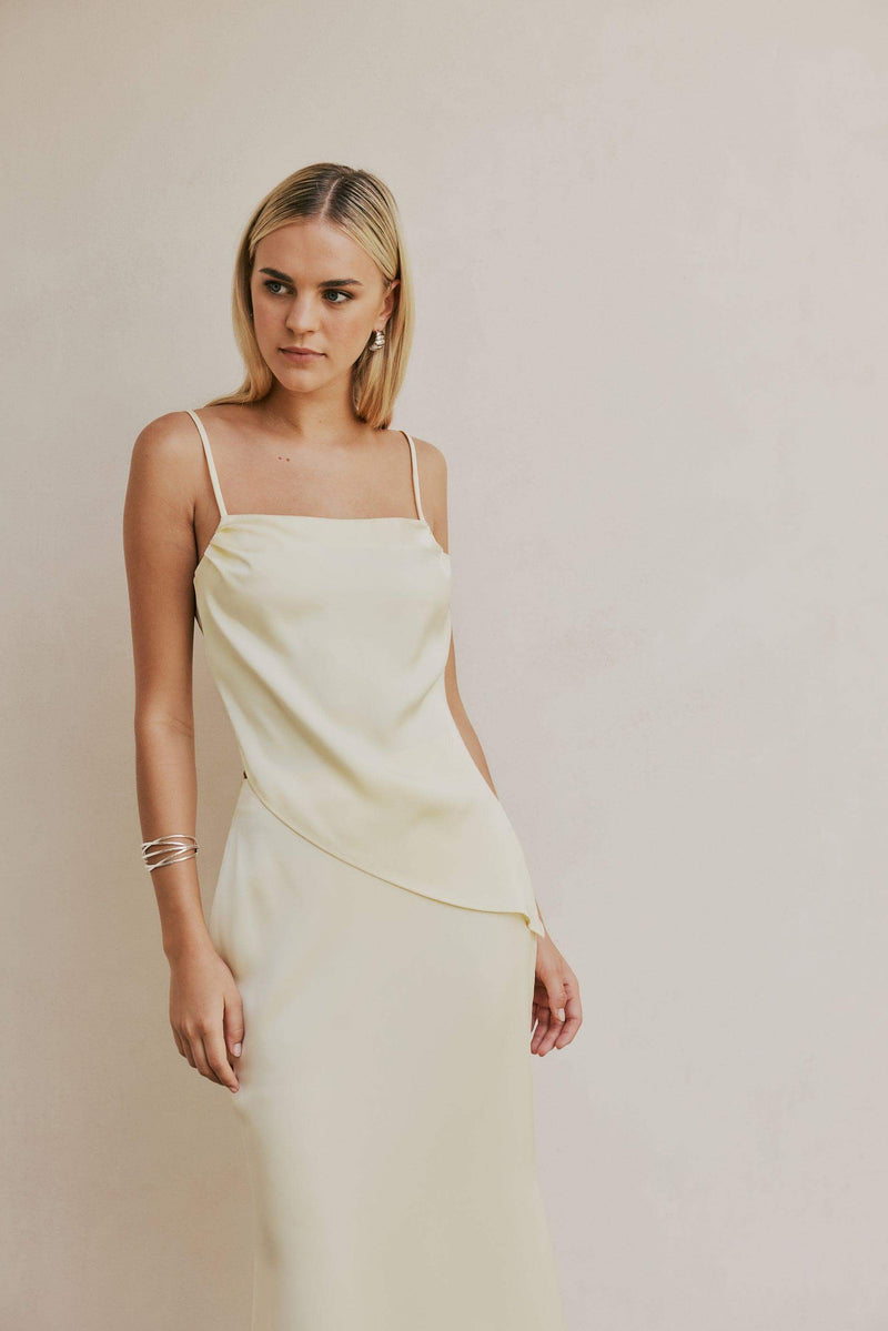 Blonde model wears CURAAE Spencer Asymmetrical Spagetti Strap Cami Top In Coco mood shot