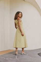 Brunette Model wears CURAAE Elenor Asymmetrical Summer Midi Dress In Olive back shot
