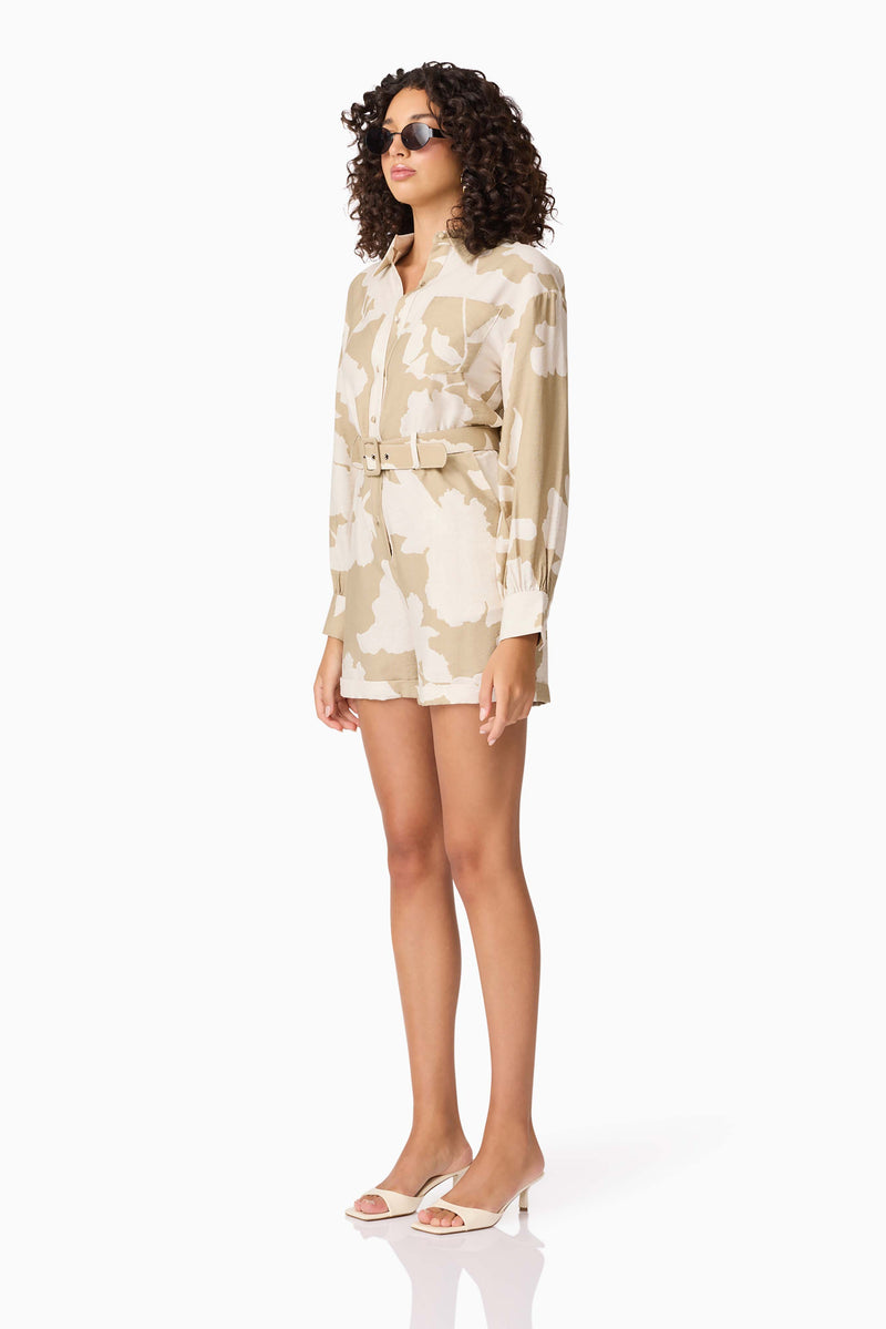 Brunette model wearing CURAAE Wisteria Long Sleeve Jumpsuit in White & Beige side shot