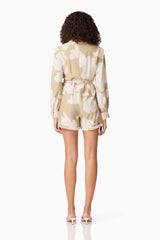 Brunette model wearing CURAAE Wisteria Long Sleeve Jumpsuit in White & Beige back shot