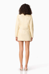 Brunette model wearing CURAAE Airlie Jacket & Mini Skirt Set in Yellow back shot
