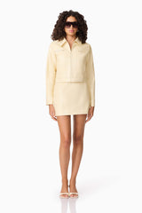 Brunette model wearing CURAAE Airlie Jacket & Mini Skirt Set in Yellow posed shot with accessories