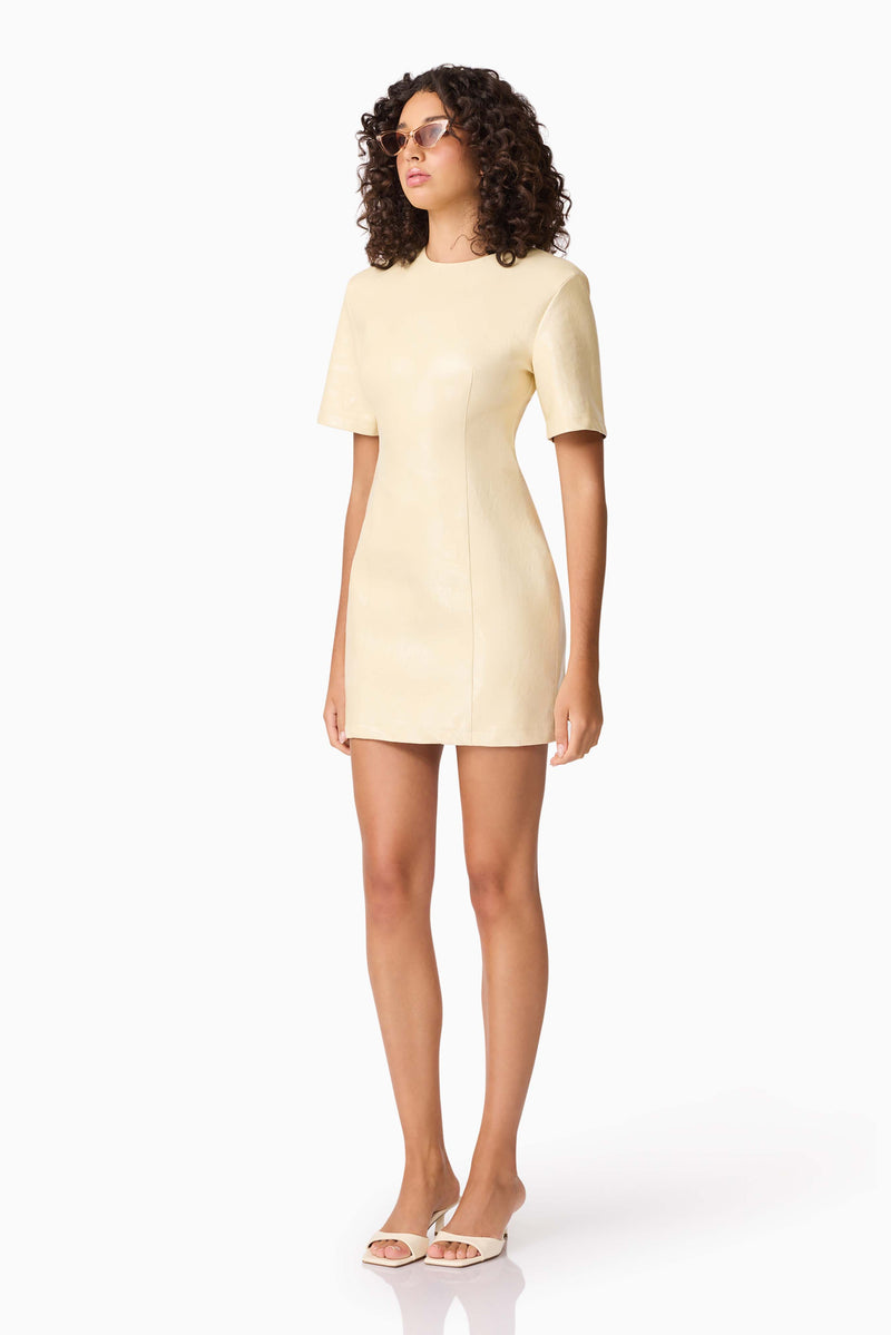 Brunette model wearing CURAAE Airlie Short Sleeve Mini Dress in Yellow side shot