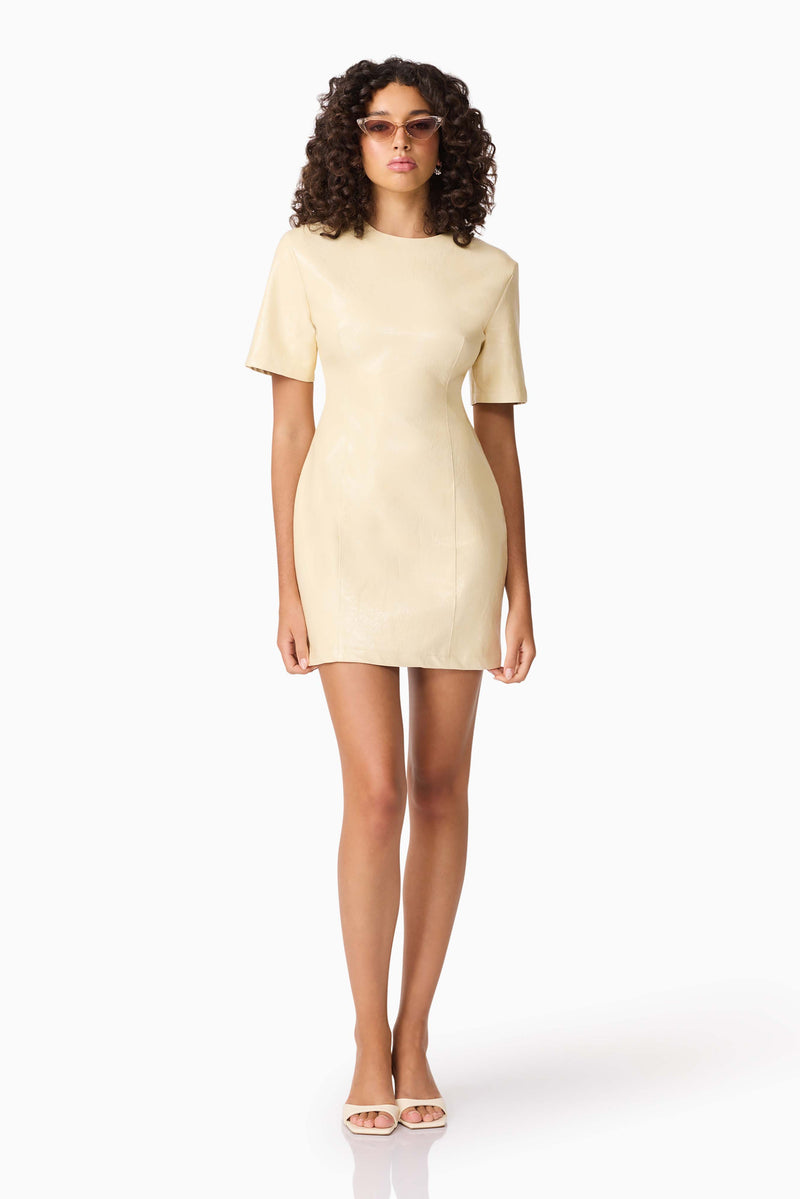 Brunette model wearing CURAAE Airlie Short Sleeve Mini Dress in Yellow posed front shot