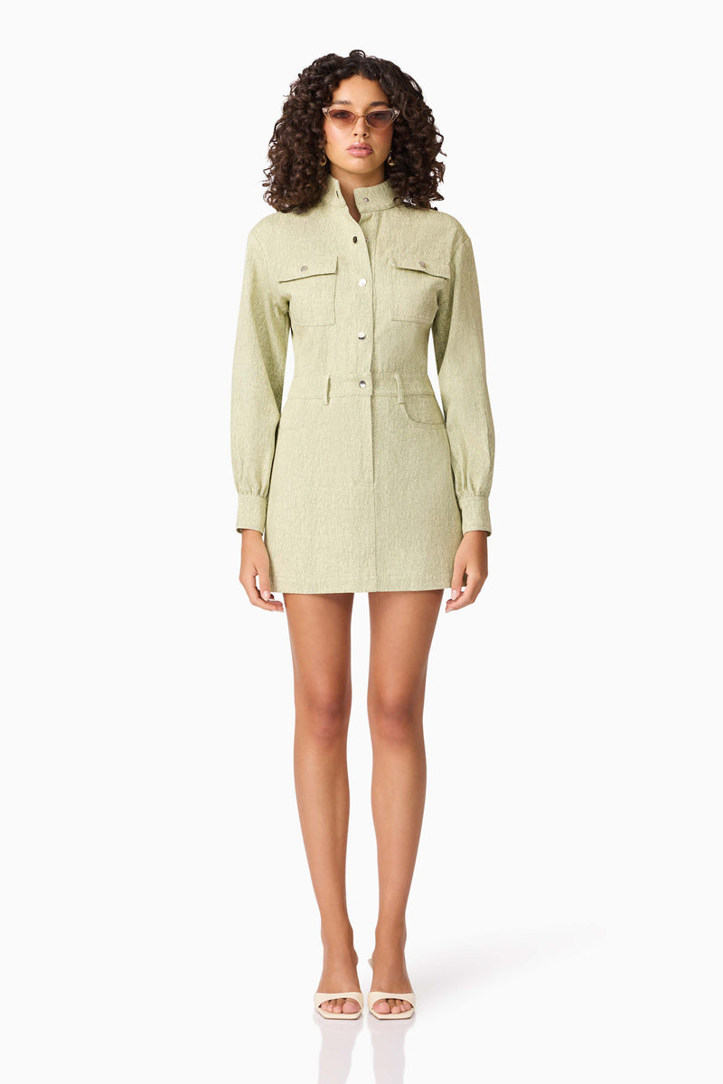 Brunette model wearing CURAAE Gretal Long Sleeve Mini Dress in Green front acessories shot