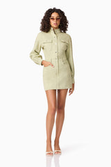 Brunette model wearing CURAAE Gretal Long Sleeve Mini Dress in Green posed hand in pocked shot