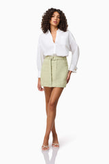 Brunette model wearing CURAAE Greta Jacket & Mini Skirt Set in Green posed shot only wearing the skirt