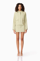 Brunette model wearing CURAAE Greta Jacket & Mini Skirt Set in Green front shot