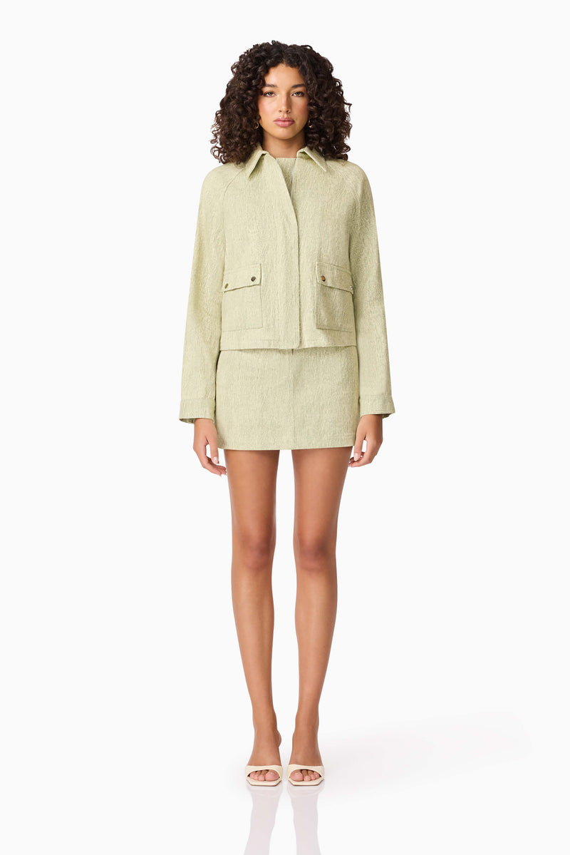 Brunette model wearing CURAAE Greta Jacket & Mini Skirt Set in Green front shot