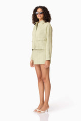 Brunette model wearing CURAAE Greta Jacket & Mini Skirt Set in Green side shot
