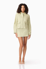 Brunette model wearing CURAAE Greta Jacket & Mini Skirt Set in Green posed looking forward shot