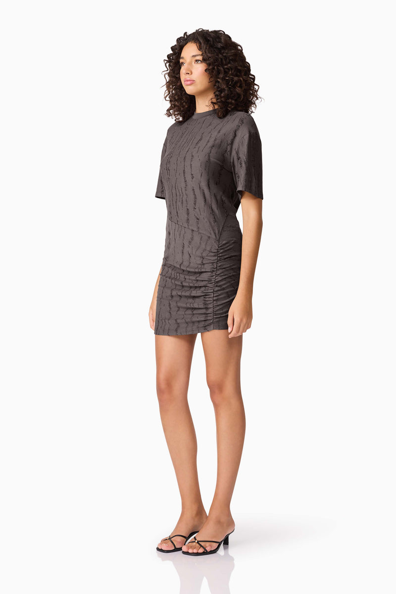 Brunette model wearing CURAAE Lavania Short Sleeve Mini Dress in Grey side shot