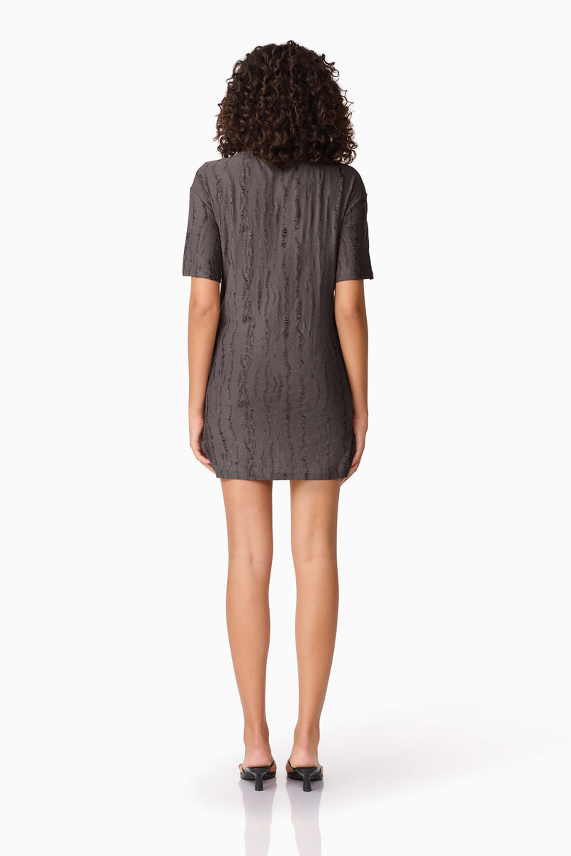Brunette model wearing CURAAE Lavania Short Sleeve Mini Dress in Grey back shot
