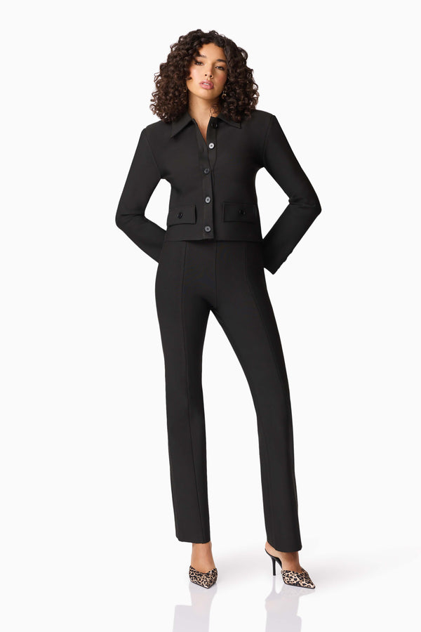 Brunette model wearing CURAAE Nora Jacket & Pants Set in Black posed hands on hip shot