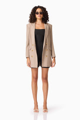 Brunette model wearing CURAAE Nora Unitard in Black posed with blazer shot