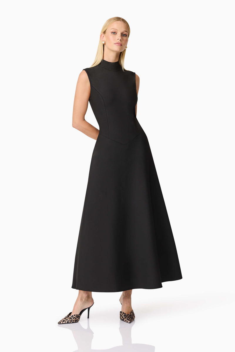 Blonde model wearing CURAAE Nora Sleeveless Midi Dress in Black posed leaning shot