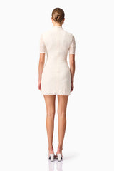 Blonde model wearing CURAAE Aura Short Sleeve Mini Dress In White back pose