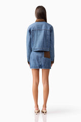 Brunette model wearing CURAAE Rhea Denim Jacket & Skirt Set back pose