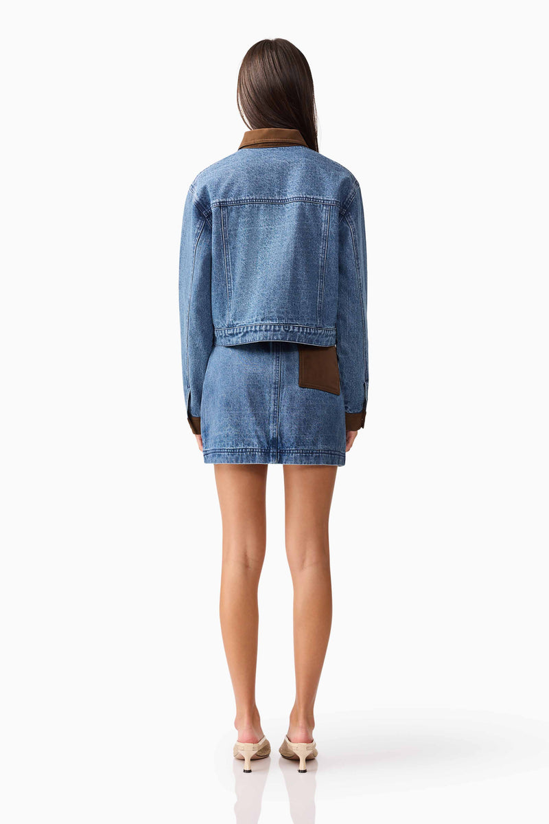 Brunette model wearing CURAAE Rhea Denim Jacket & Skirt Set back pose
