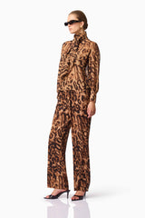 Blonde model wearing CURAAE Zali Bloudse & Pants Set in Leopard Print side pose with accessories