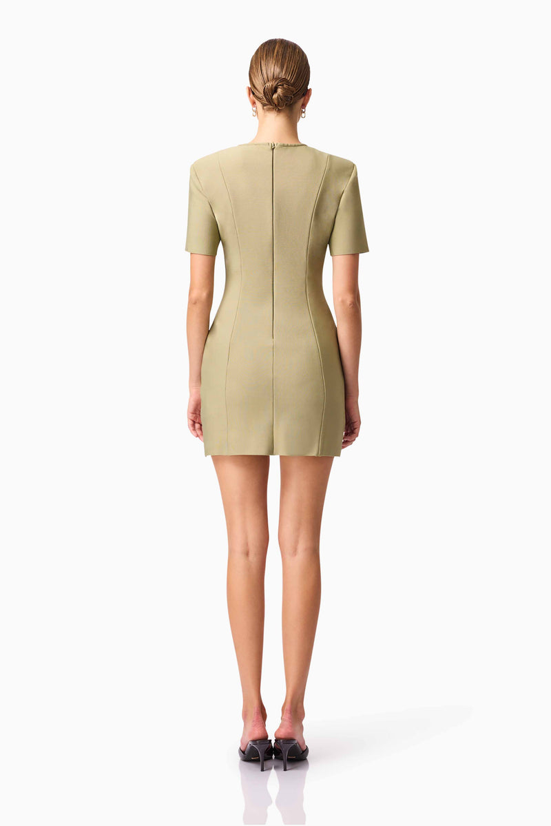 Blonde model wearing CURAAE Dua Short Sleeve Mini Dress in Green back pose