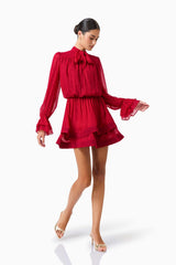 CURAAE Zanetta Long Sleeve Mini Dress in Berry Red with long sleeves and a tie neckline posed walking shot