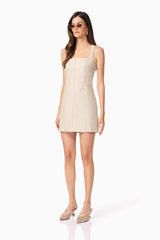 Brunette model wears Celina Leather Mini Dress In Beige side shot