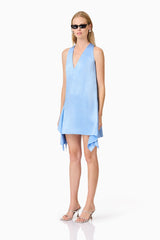 A blonde model wearing a blue mini dress side shot