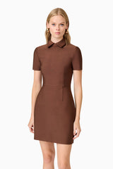 A blonde model wearing a brown collared mini dress close up shot