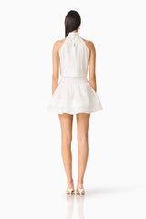 Brunette woman wearing the CURAAE Estrella Mini Dress in White back shot