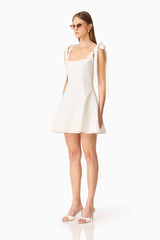 Brunette model wearing the Chantel Mini Dress in White side shot 
