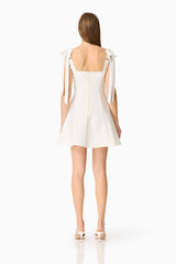 Brunette model wearing the Chantel Mini Dress in White back shot 
