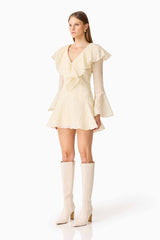 Brunette model wearing the Maribelle Long Sleeve Mini Dress in Lemon Yellow side shot