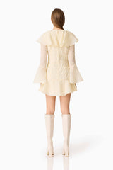 Brunette model wearing the Maribelle Long Sleeve Mini Dress in Lemon Yellow back shot