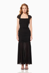 Blonde model wearing the Capra Maxi Dress In Black front shot