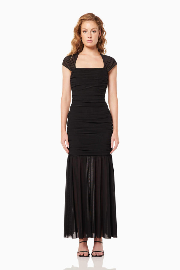 Blonde model wearing the Capra Maxi Dress In Black front shot