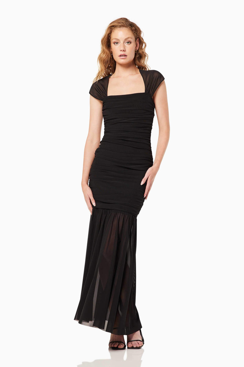 Blonde model wearing the Capra Maxi Dress In Black posed shot