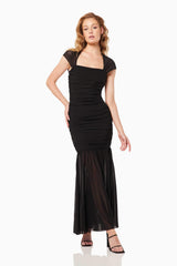 Blonde model wearing the Capra Maxi Dress In Black posed hand on hip shot